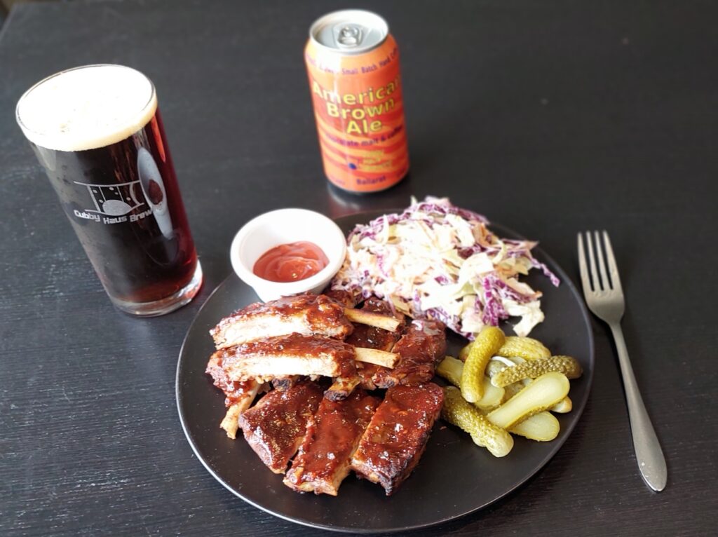 Slow cooked pork ribs and coleslaw with glass and can of American Brown Ale