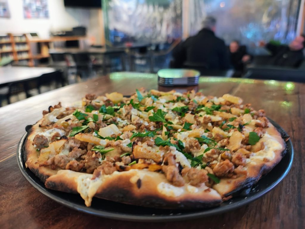 pork and fennel pizza on serving plate