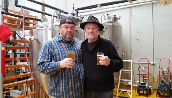 Two mates in brew house with beers