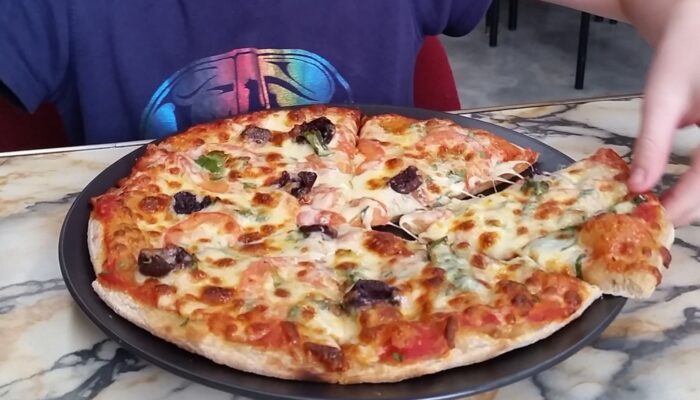 Tobias grabbing a slice of pizza