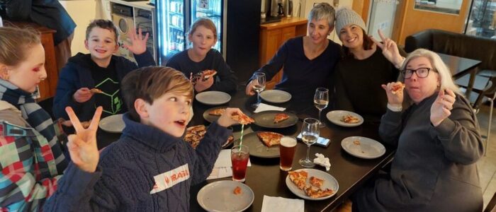 family at table eating, drinking and chering