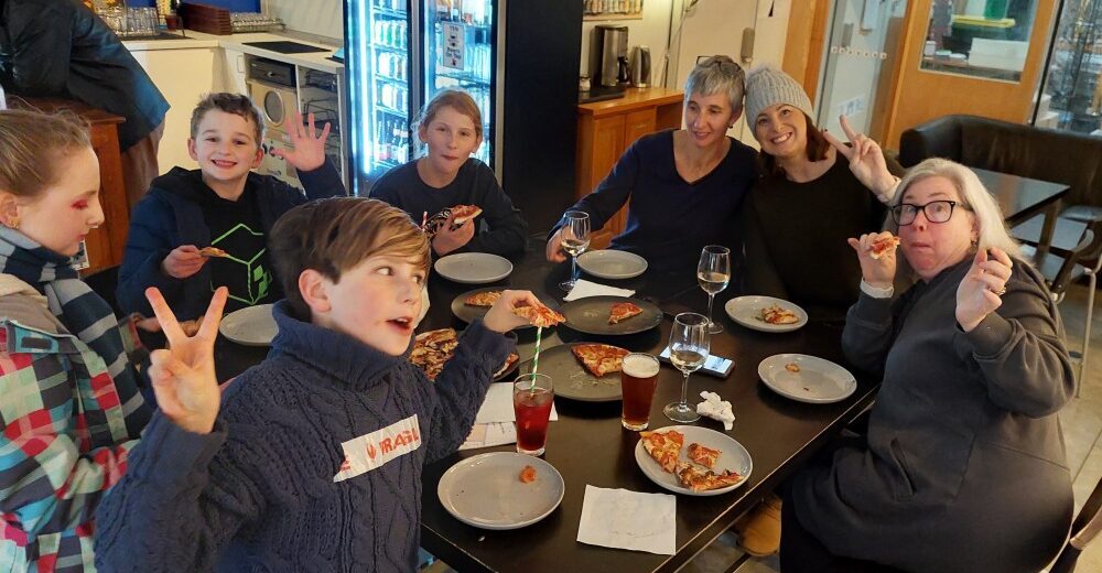 family at table eating, drinking and chering