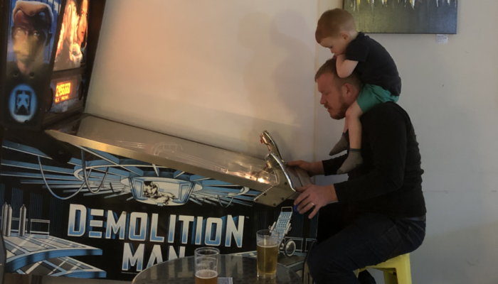 Sam with James on shoulders playing pinball
