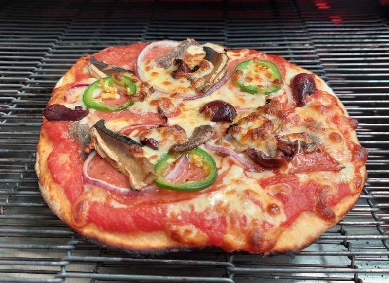 cooked pizza on oven conveyor