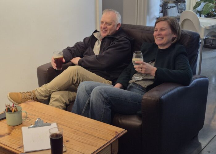 A couple relaxing on the couch with drinks