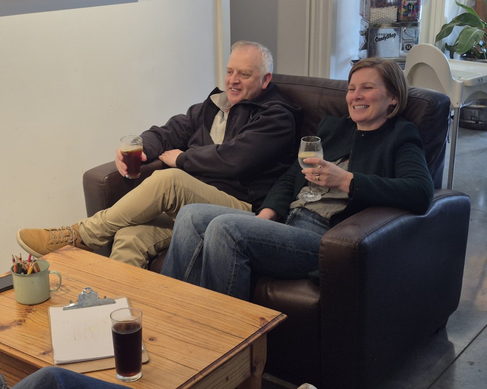A couple relaxing on the couch with drinks
